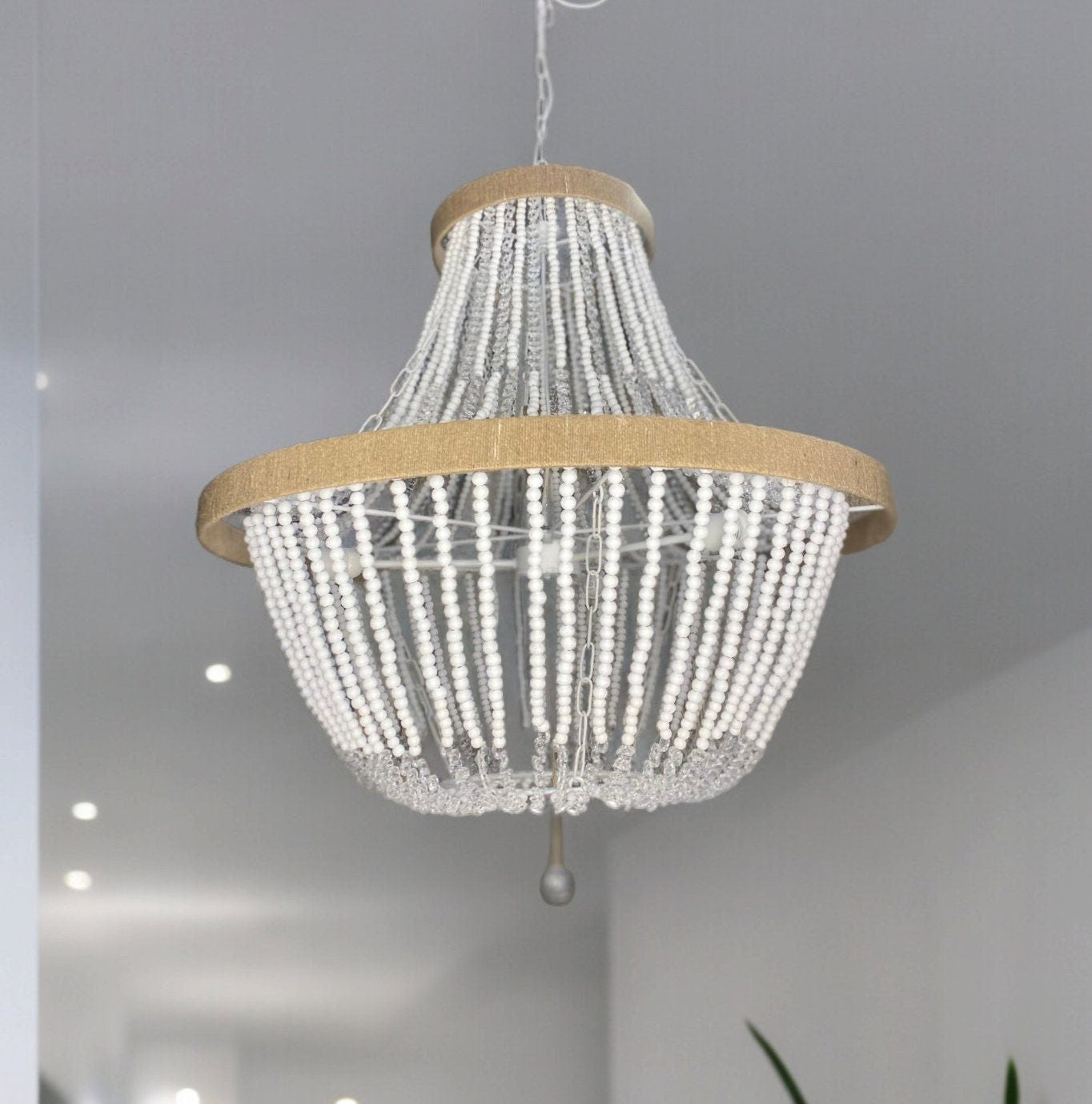 Measuring 70 cm in diameter, the handmade chandelier features a combination of natural wooden beads and sparkling crystal details. The mix of rustic wooden beads and crystal strands make this chandelier a stunning centrepiece.